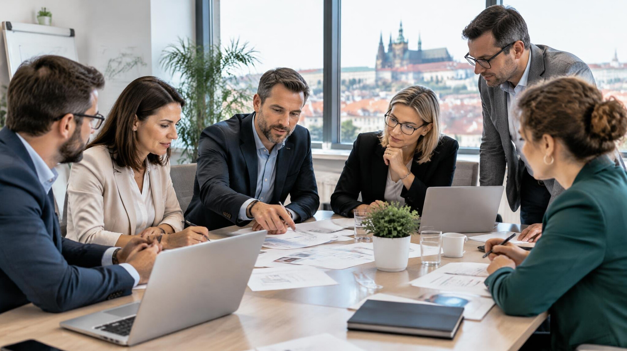Business meeting around a table with documents and laptops