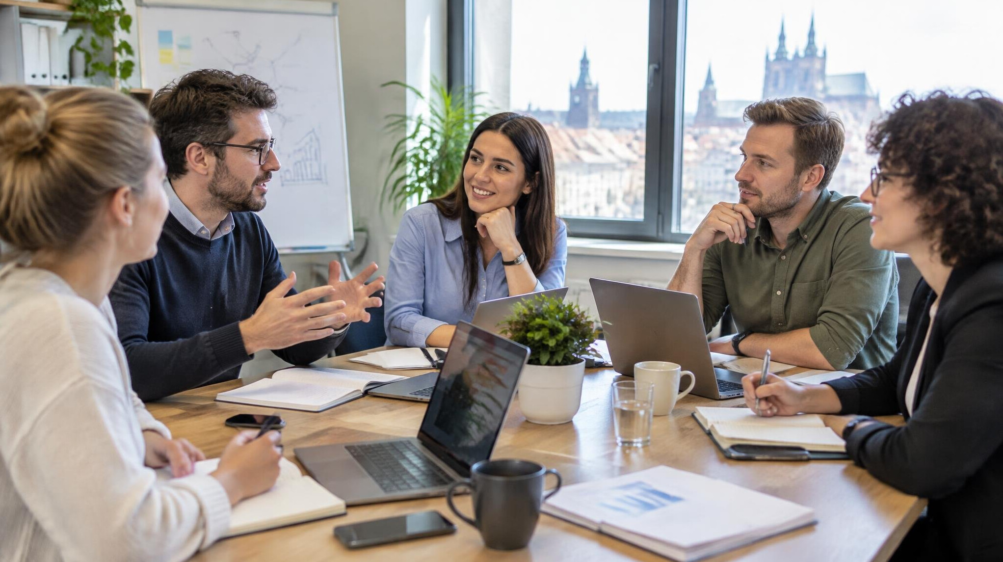 Group of colleagues brainstorming strategy around a table with laptops